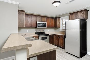 A kitchen with a refrigerator and wooden cabinets